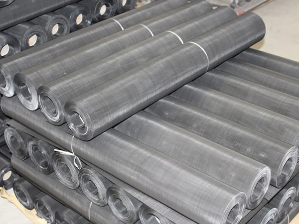 Many rolls of black wire cloth stacked together