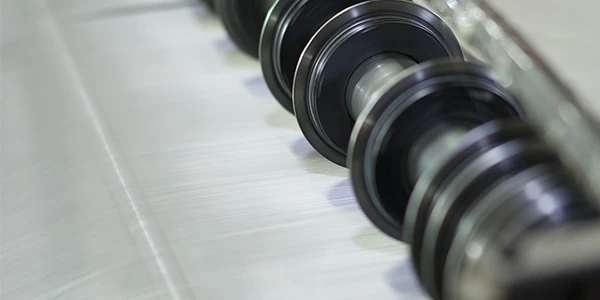 A slitting machine is slicing the woven mesh into strips