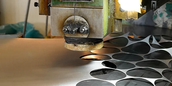 A person operating a machine to perform stamping on woven wire mesh