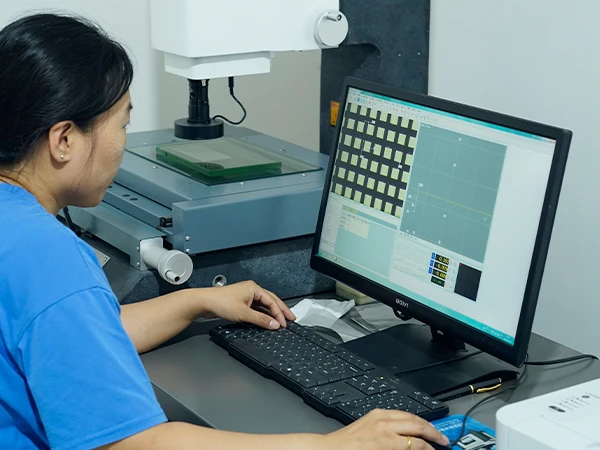 A worker is inspecting the mesh opening size of the woven mesh.