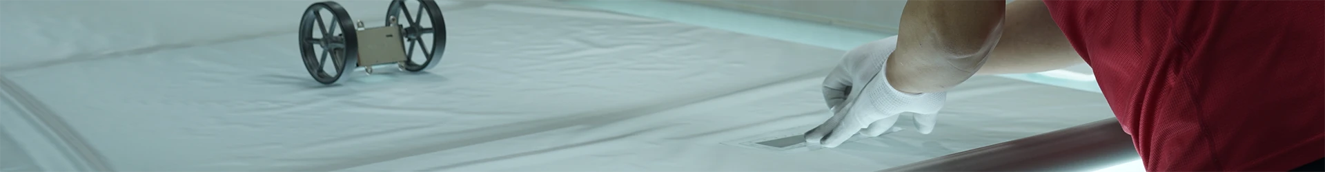 A worker is checking the length of woven mesh.