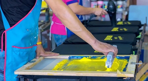 2 workers are conducting screen printing.