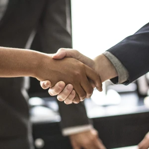 2 men are shaking their hands.