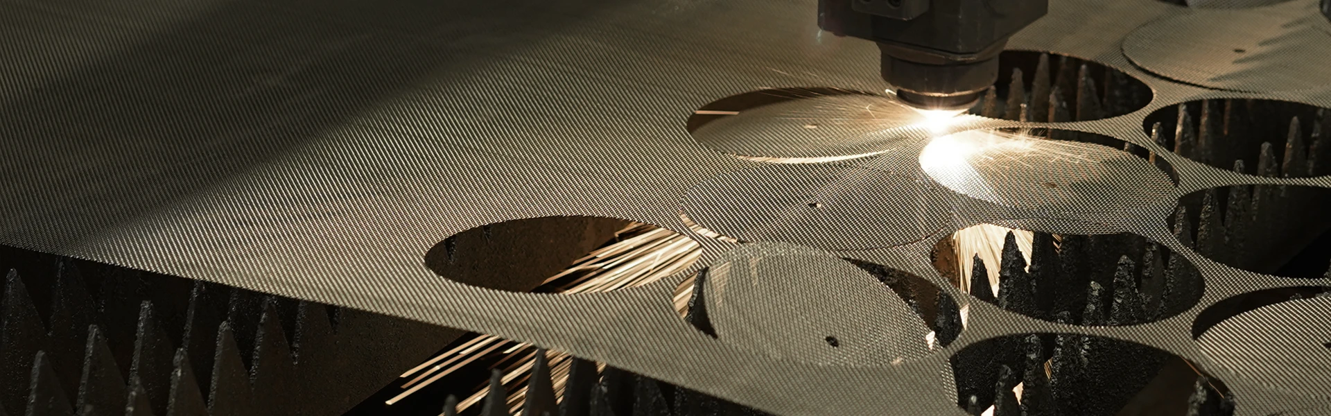 A laser cutting machine is cutting the woven mesh into round discs.