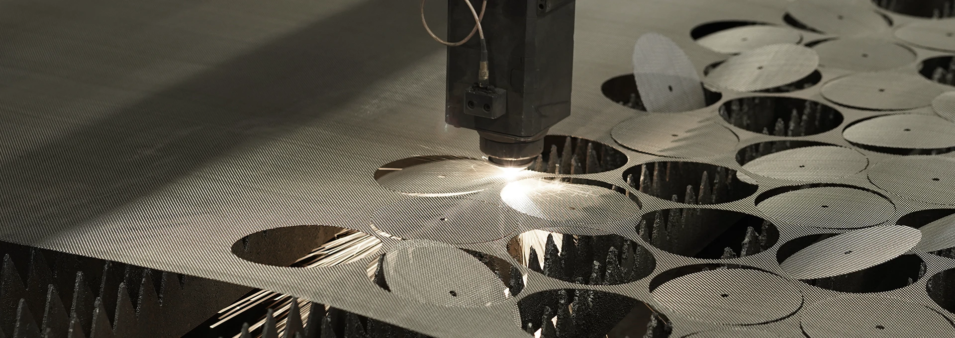 A woven mesh processing equipment is laser cutting the woven mesh.