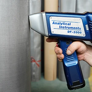 A person holding a tester for woven mesh chemical composition inspection