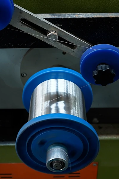 3 stainless steel wire coils are placed onto the machine.