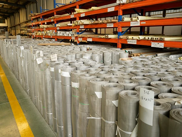 Different types of woven mesh products are placed in the warehouse.